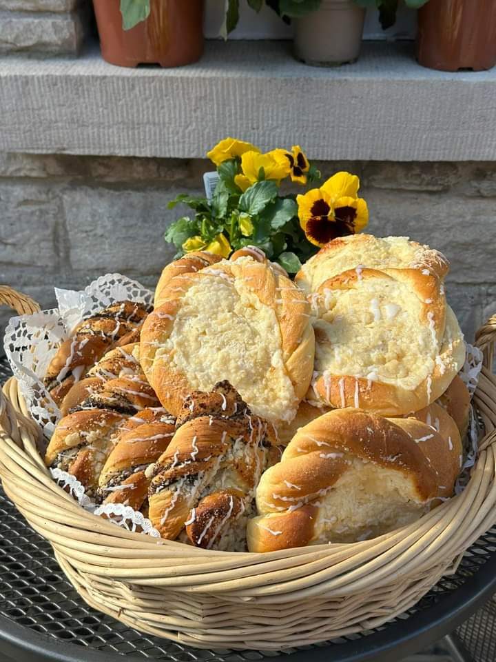 A basket of pastries and bread with pansies